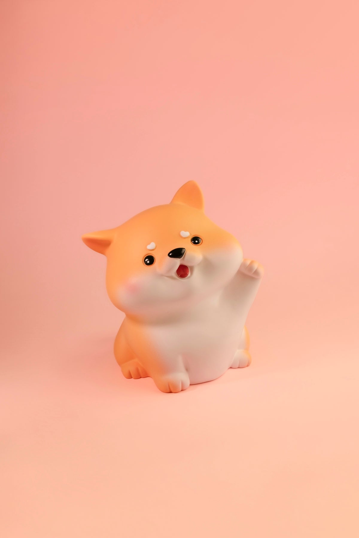 a small figurine of a dog on a pink background